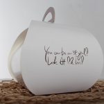 Objet blanc avec message écrit, sur un tapis, arrière-plan gris