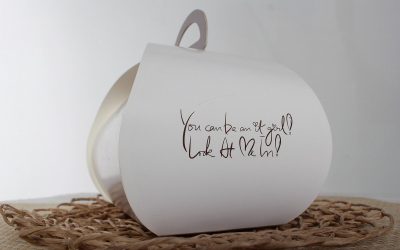 Objet blanc avec message écrit, sur un tapis, arrière-plan gris