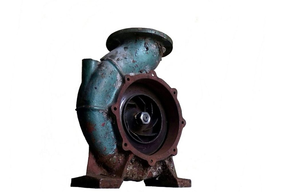 Pompe industrielle rouillée avec turbine apparente, fixée sur socle