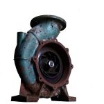 Pompe industrielle rouillée avec turbine apparente, fixée sur socle