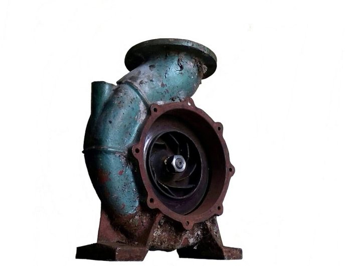 Pompe industrielle rouillée avec turbine apparente, fixée sur socle